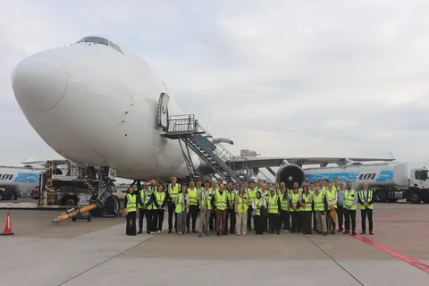 IARO delegates in high-visibility vests lined up on the cargo apron at Brussels Airport, in front of a Boeing 747 freighter with its nose open